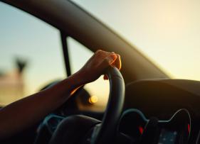 a person's hand on the steering wheel of a car