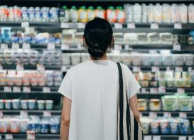 a woman standing in front of a stocked aisle in a shop
