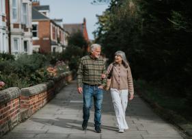 an old couple out on a walk in a residential neighbourhood