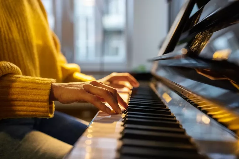 two hands playing piano keys