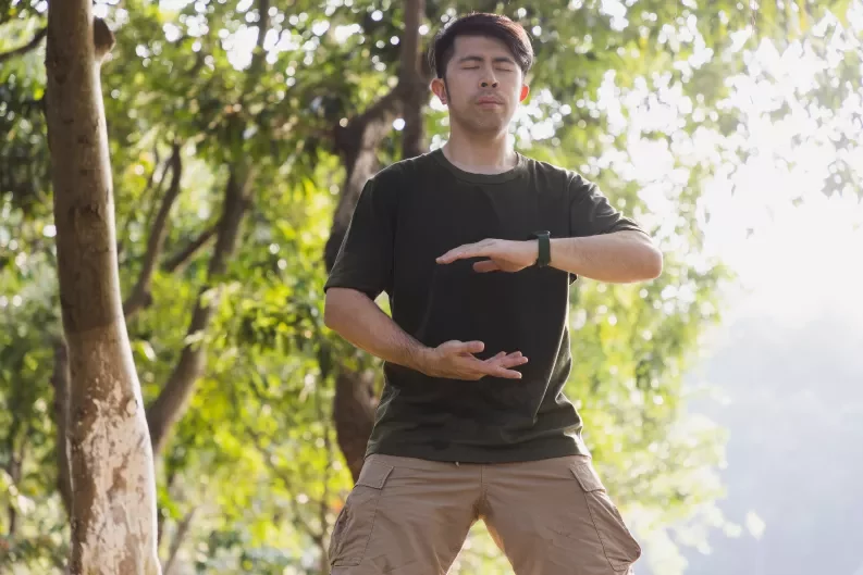man practicing tai chi in a park