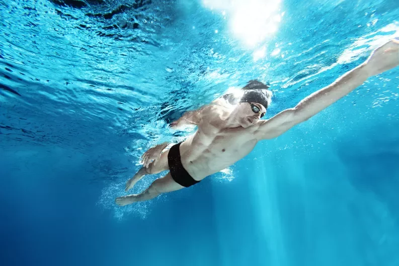 a man swimming freestyle in a pool