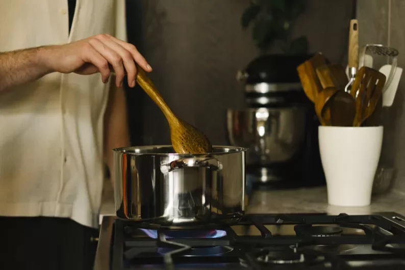 a man stirring a pot on the stove