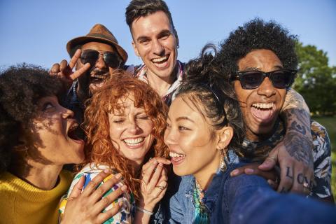 a group of friends laughing and taking a selfie