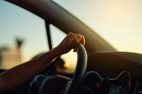 a person's hand on the steering wheel of a car