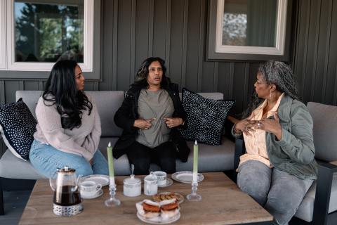 a group of women sitting on a couch around a table in deep discussion